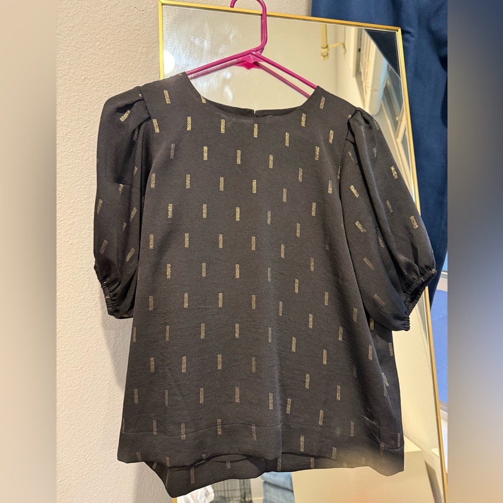 Madewell black top with puffy sleeves and gold pattern detail.